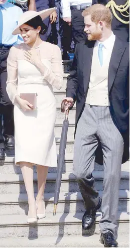  ??  ?? On their first official engagement as a married couple at Prince Charles’ 70th birthday garden party, Meghan wears a dress by GOAT, bespoke hat by Philip Treacy and pumps by Tamara Mellon.
