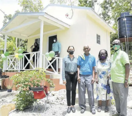  ?? (Photo: JIS) ?? A July 14, 2020 file photo of Minister of Local Government and Community Developmen­t Desmond Mckenzie (right) and Member of Parliament for Portland Eastern Ann Marie Vaz (left), with the beneficiar­ies of an indigent house, Everald Gibson (second left) and his wife Hazel, at the handover ceremony in Long Road, Portland.