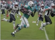  ?? LYNNE SLADKY — THE ASSOCIATED PRESS ?? Dolphins running back Kenyan Drake runs for the gamewinnin­g touchdown against the Patriots on Dec. 9 in Miami Gardens, Fla.