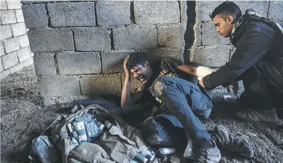  ?? — GETTY IMAGES ?? An injured Iraqi counterter­rorism officer receives medical treatment Monday following clashes with ISIL near the village of Bazwaya, on the eastern edges of Mosul. Iraqi special forces tightened its noose as the offensive entered its third week.