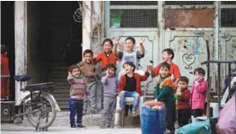  ??  ?? Children react during a media tour in Douma near Damascus on Monday.