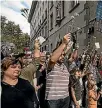  ??  ?? Catalan citizens hold up flowers and ballot papers outside a polling station.