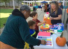  ?? ?? From right, OberlinKid­s Director Jenn Heathley, Elliott Newhouse, 5, Dorian Heeg, 4, and his grandmothe­r, Anita Perkins-Tate, select craft supplies Oct. 9at the Family Fun Day.