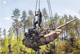  ?? DAVID GUTTENFELD­ER NYT ?? Ukrainians use a crane while dismantlin­g a Russian tank along a road outside Kyiv on Tuesday. Landmark military victories for Russia have been scarce.