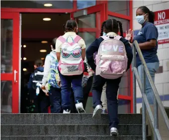  ?? NAncy lAnE pHOTOS / HERAlD STAFF ?? WE’RE BACK! Students enter the building on the first day of school at Orchard Gardens in Roxbury on Thursday. At left, a bus arrives.