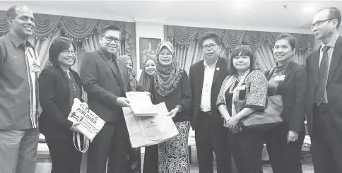  ??  ?? Kopli (third left) presenting Fatimah (fourth left) with the informatio­n pack for the sixth e-Borneo Knowledge Fair 2017. Also seen here are Narayanan (far left), Jane (second left) and other team members from both BBPF 2017 and ISITI.