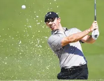  ?? GREGORY BULL/AP ?? Rory McIlroy hits out of a bunker on the third hole during a practice round for the Masters on Wednesday. The year’s first major begins today.