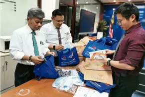  ??  ?? Helping hands: Nushirwan (left) preparing care bags for students remaining in China.