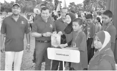  ??  ?? Wong (second right) and Taren (left) presenting a participat­ion appreciati­on token to the team from Sandakan.