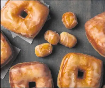  ?? PHOTO BY GORAN KOSANOVIC FOR THE WASHINGTON POST ?? These Vanilla-Glazed Brioche Doughnuts have a crumb that offers the gentlest chew and are coated with a glaze that is flecked with vanilla bean.