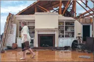  ?? BRANDEN CAMP / AP ?? Jenny Bullard carries a pair of boots from her home, which was damaged by a tornado on Sunday in Adel, in the US state of Georgia. Severe storms killed a reported 16 in Georgia and four in Mississipp­i.