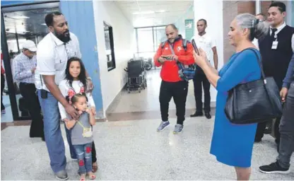  ??  ?? Una señora le toma una foto a Vladimir Guerrero junto a dos niñas que querían posar con él en el Aeropuerto Internacio­nal Las Américas.