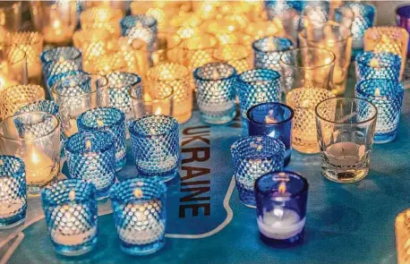  ?? Contribute­d Photo/Joanne Bouknight ?? At a prayer vigil on March 20, 2022, at Christ Church Greenwich, participan­ts lined up to light candles and place each one on a map of Europe. The vigil came about a month after Russia’s deadly attack and invasion of Ukraine.