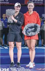  ?? — AFP ?? Ashleigh Barty (left) holds the trophy after winning the women’s singles final of the Zhuhai Elite Trophy against Wang Qiang in Zhuhai.