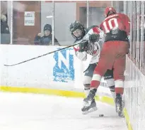  ?? JASON SIMMONDS/JOURNAL PIONEER ?? Kensington Wild forward Reid Peardon and the Fredericto­n Caps’ Jeremie Thibodeau battle for the puck during a New Brunswick/ Prince Edward Island Major Midget Hockey League game at Credit Union Centre in Kensington on Saturday night. The Wild won the contest 2-1.