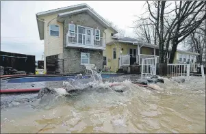 ?? CP PHOTO/JUSTIN TANG ?? Rising water from the Ottawa River is nearly level with the deck and swimming pool at a home in Rockland, Ont., about 40 kilometres east of Ottawa, on Sunday. Insurance industry experts say many Canadian homeowners aren’t insured for flooding and could...