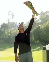  ?? RYAN KANG — THE ASSOCIATED PRESS ?? Adam Scott hoists his trophy on the 18th green after winning the Genesis Invitation­al.