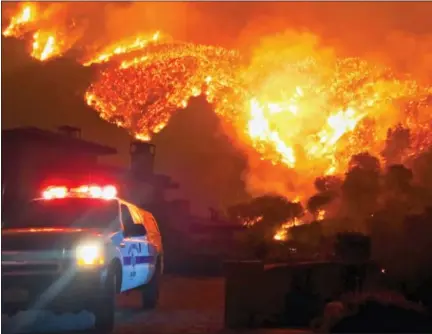  ?? MIKE ELIASON/SANTA BARBARA COUNTY FIRE DEPARTMENT VIA AP ?? In this photo provided by the Santa Barbara County Fire Department, fire burns canyons and ridges above Bella Vista Drive near Romero Canyon as the fight to contain a wildfire continues in Montecito, Calif., Tuesday, Dec. 12, 2017.