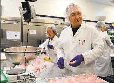  ?? DAN HONDA — STAFF PHOTOS ?? Pat McGale, a product developmen­t technician, turns Impossible Burger balls into patties at the Impossible Foods offices in Redwood City on Tuesday. The company has developed a meatless “burger” that is currently being sold in some restaurant­s.