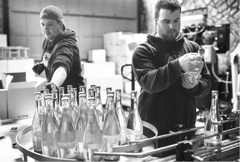  ??  ?? Humphrey, left, and Benson work at the end of the production line at Blue Bee Cider.