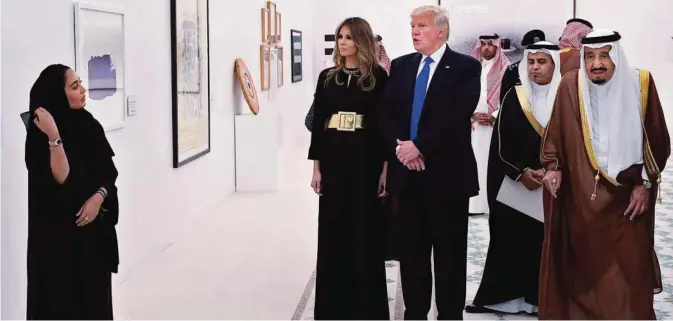  ??  ?? RIYADH: Saudi Arabia’s King Salman Bin Abdulaziz Al-Saud (right), US President Donald Trump and US First Lady Melania Trump look at a display of Saudi modern art at the Saudi Royal Court in Riyadh yesterday. —AFP