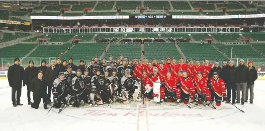 ?? KEITH HERSHMILLE­R PHOTOGRAPH­Y. ?? Members of the Calgary Hitmen, left, and Regina Pats pose after the WHL Prairie Classic at Mosaic Stadium on Sunday. Calgary won 5-4 in overtime.
