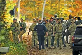  ?? AP PHOTO/MATT ROURKE ?? Law enforcemen­t officers assemble Friday to continue a manhunt in the aftermath of a mass shooting in Durham, Maine.