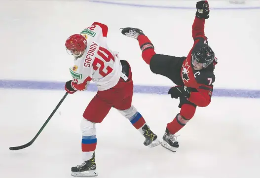  ?? GREG SOUTHAM ?? Canadian captain Kirby Dach tumbles after colliding with Russia's Ilya Safonov during Wednesday's tuneup. Dach hurt his wrist on the play and is out for the tournament.