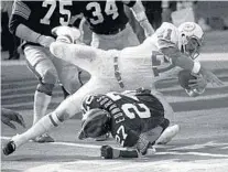  ?? AP 1972 ?? Miami Dolphins’ Jim Kiick goes over Pittsburgh Steelers’ Glen Edwards in the AFC championsh­ip at Pittsburgh’s Three Rivers Stadium.