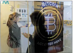  ?? AP/KIN CHEUNG ?? Customers use a bitcoin ATM in Hong Kong on Dec. 8. The virtual currency’s skyrocketi­ng price on private exchanges this year has piqued the interest of Wall Street.