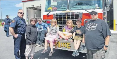  ?? JEREMY FRASER/CAPE BRETON POST ?? Members of the community, young and old, were in attendance for the grand opening of the new Sydney fire station on Victoria Road. Seen are some of the people in attendance for the opening, sitting on the front of a fire truck, from left, Stephen...