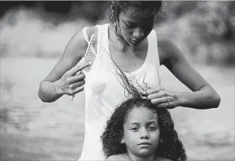  ?? REBECCA BLACKWELL THE ASSOCIATED PRESS ?? A Honduran migrant girl gets her hair combed after bathing in the river in Tapanatepe­c, Mexico, Sunday.