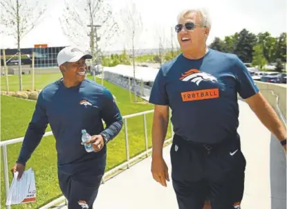  ?? Joe Amon, The Denver Post ?? Broncos coach Vance Joseph and general manager John Elway walk to the Broncos’ annual media BBQ at Dove Valley on Friday. Joseph, Elway and team president/CEO Joe Ellis all addressed the media at the event.