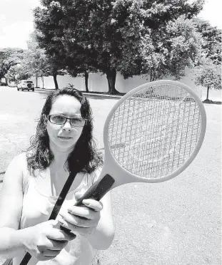  ?? Rivaldo Gomes/folhapress ?? A dona de casa Viviane de Paula, 33 anos, em frente ao cemitério da Vila Formosa (zona leste), com a raquete que tem usado para espantar mosquitos,