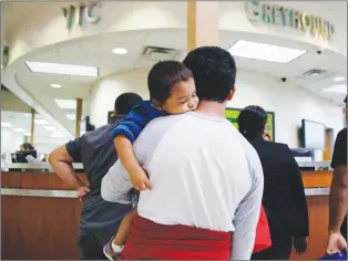  ?? AP PHOTO ?? A group of immigrants from Honduras and Guatemala seeking asylum stand in line at the bus station after they were processed and released by U.S. Customs and Border Protection, Thursday.