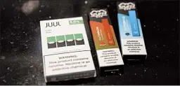  ?? MARSHALL RITZEL/AP ?? A Juul pod is compared to the tinier disposable vaping devices at a store in New York.