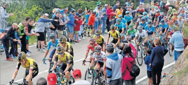  ??  ?? El pelotón de la Vuelta rueda camino de La Cubilla durante la pasada edición ante el numeroso público que aplaude y saca fotos a los corredores.