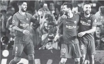  ??  ?? Barcelona’s Luis Suarez (left) and Jordi Alba (right) celebrate with Lionel Messi, who scored twice in a 3-0 win over Juventus in their Champions League Group D in Barcelona yesterday.