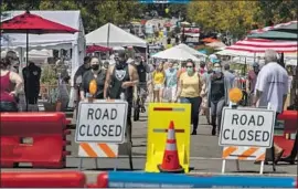  ?? Brian van der Brug Los Angeles Times ?? OFFICIALS are hopeful that the use of face masks, like those seen Saturday in Ventura, will help slow the spread of the virus. Recent test data are in doubt.