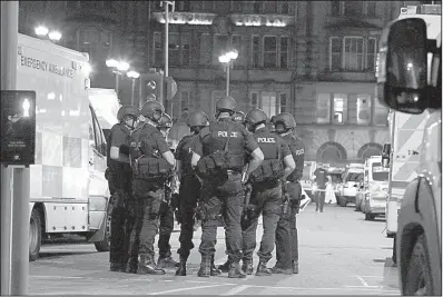  ?? AP/PETER BYRNE ?? Police gather at Manchester Arena on Monday after an explosion rocked the venue during an Ariana Grande concert in Manchester, England.