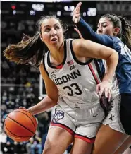  ?? Jessica Hill/Associated Press ?? UConn’s Caroline Ducharme (33) is defended by Xavier’s Fernanda Ovalle (10) in the first half on Monday in Storrs.