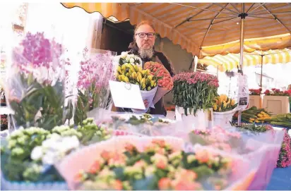  ?? RP-FOTO: ACHIM BLAZY ?? Blumenhänd­ler Christof Schmitt an seinem Stand auf dem Marktplatz. Er verkauft die Blumen nach Anzahl, seine Frau Andrea bindet Sträuße.