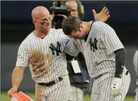  ?? JULIE JACOBSON — THE ASSOCIATED PRESS ?? New York Yankees’ Brett Gardner, left, congratula­tes Neil Walker after Walker drove in the winning run against the Oakland Athletics during the eleventh inning of a baseball game, Saturday in New York. The Yankees won 7-6.