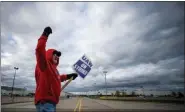  ?? JAKE MAY/THE FLINT JOURNAL VIA AP ?? Jimmy Mangrym, a 63-year-old Flint native who has 43 years in at Flint Metal Fabricatio­n in tool and dye, circles in front of an entrance to Flint Engine Operations as UAW members line the street with picket signs on the 32nd day of the nationwide UAW strike against General Motors after stalled contract negotiatio­ns on Thursday in Flint, Mich.