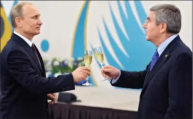  ??  ?? How close are they? Putin and Bach toast champagne ahead of the Sochi Winter Olympics in 2014