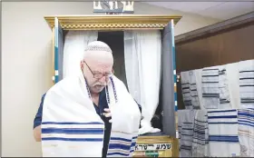  ?? (NWA Democrat-Gazette/Charlie Kaijo) ?? Cantor Samuel Radwine drapes himself with a tallit, a prayer shawl, Sunday at the Congregati­on Etz Chaim in Bentonvill­e.