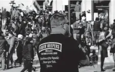  ?? Paul Sancya/Associated Press ?? A man wearing an Oath Keepers shirt stands outside the Kenosha (Wis.) County Courthouse last year.