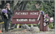 ?? AP/JOSH EDELSON ?? A woman in Yountville, Calif., places flowers Saturday at a sign for the Pathway Home, a nonprofit that aids veterans on the campus where a former Army infantryma­n fatally shot three people Friday before killing himself.
