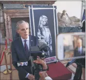  ??  ?? Franch Ambassador to Italy Christian Masset stands by a recovered stolen artwork by British artist Banksy during a ceremony at the French Embassy in Rome on Tuesday.