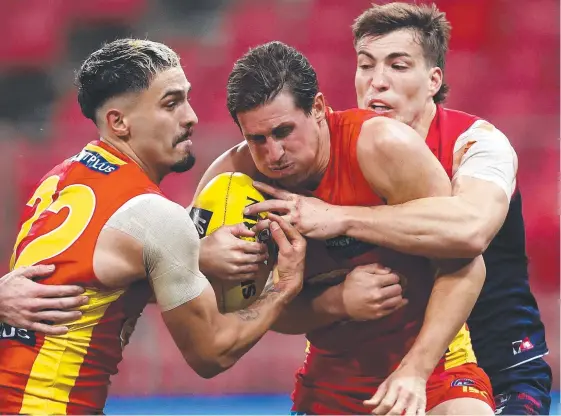  ?? Picture: GETTY IMAGES ?? The Suns’ David Swallow (centre) is tackled as Izak Rankine gathers the ball during the Round 6 clash with the Melbourne Demons.